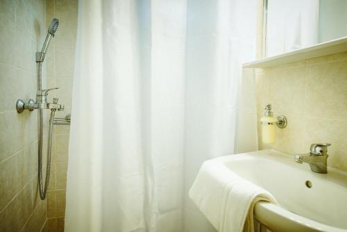 a bathroom with a shower curtain and a sink at Sea Breeze Rooms in Armenistis