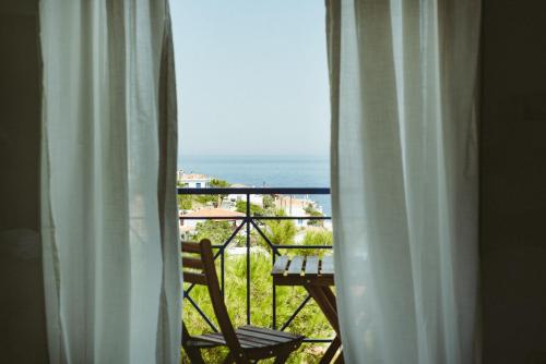 a room with a view of the ocean from a window at Sea Breeze Rooms in Armenistis