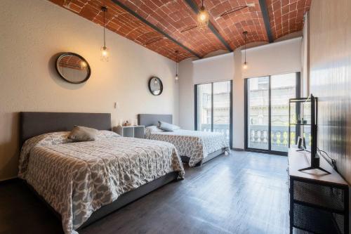 a bedroom with two beds and a large window at 205 Zocalo Cathedral 2bdrmB 2Bath fits 10 AC Apt in Mexico City