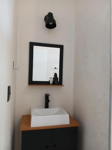 a bathroom with a white sink and a mirror at Suíte Casal com Hidro no Centro - Infinito Particular in Guararema