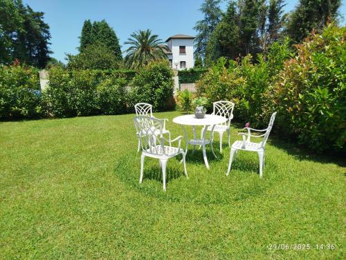 a table and chairs in the grass in a yard at Cabárceno Chalet vacacional Casa Pedro La Abadilla in La Abadilla