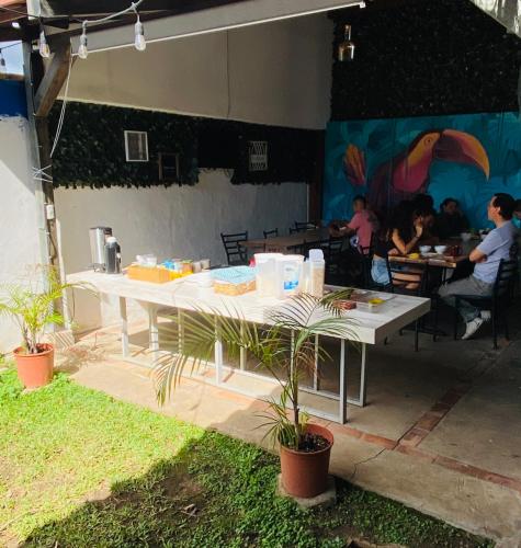 a white table with people sitting at tables in a restaurant at Casa Escalante Hostel in San José