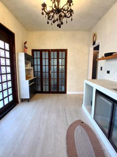 a large kitchen with a chandelier in a room at Suíte Casal com Hidro no Centro - Infinito Particular in Guararema