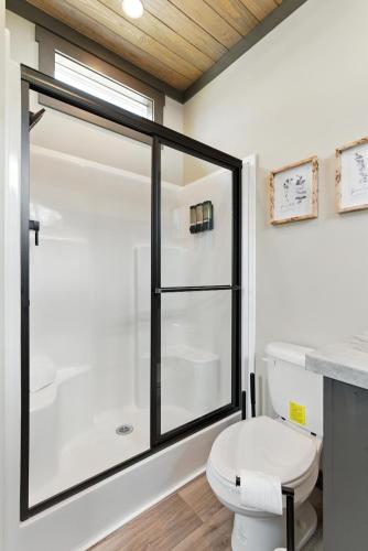 a bathroom with a toilet and a glass shower at Pigeon Forge Landing RV Resort in Pigeon Forge