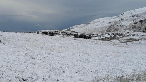 a snow covered hill with a mountain in the background at An Teach Beag Glencolmcille, little home from home in Glencolumbkille