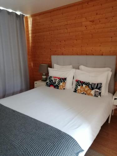 a bedroom with a large white bed with pillows at Calheta Glamping Pods - Nature Retreat in Calheta