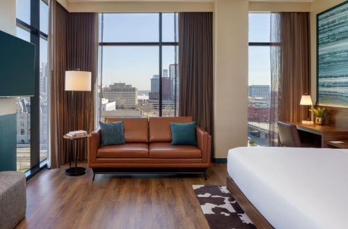 a living room with a couch and large windows at Caption By Hyatt Downtown Nashville - The Gulch in Nashville