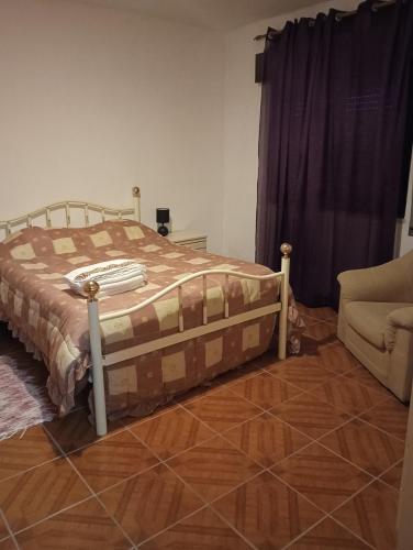 a bedroom with a bed and a couch and a chair at Casa das Lezírias in Unhais da Serra