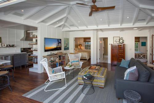 a living room with a blue couch and chairs at The Cottage at West Beach by Paradise Retreats in Santa Barbara