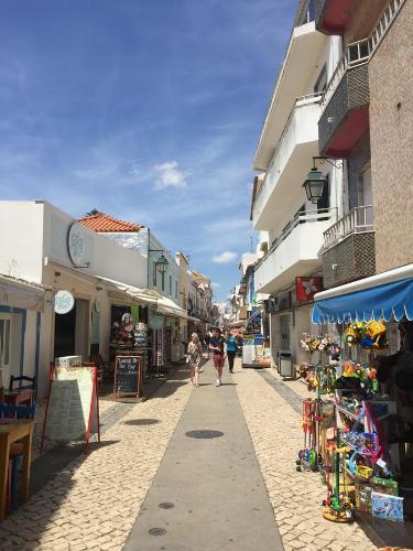 a group of people walking down a street with buildings at Casinha Teles in Alvor