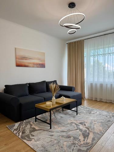 a living room with a blue couch and a coffee table at Emerald - Modern Central Apartment in Tîrnăveni