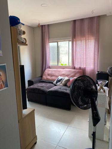 a living room with a couch and a fan at Casa para COP30 in Ananindeua