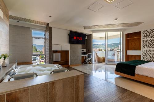 a bedroom with a bed and a tub and a television at Terra Biohotel in Medellín