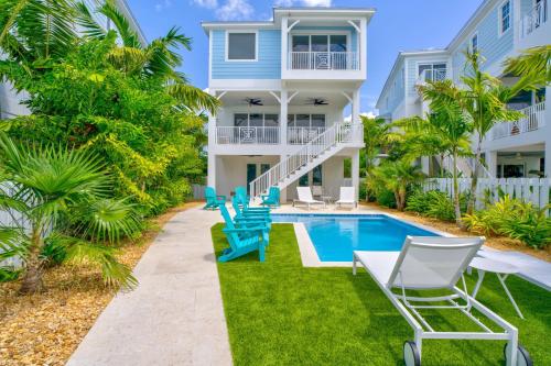 a villa with a swimming pool and lounge chairs at Emerald Tides - Luxury Oceanfront Home, Private Pool, 30' Dock in Marathon