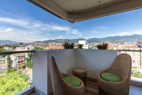 a balcony with chairs and a view of a city at Terra Biohotel in Medellín