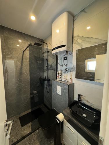 baño pequeño con ducha y lavamanos en Borak Apartmani, en Sutivan