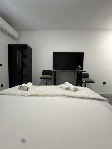 1 dormitorio con 1 cama blanca y TV en Borak Apartmani, en Sutivan