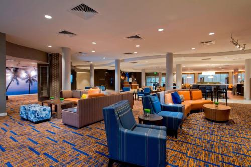 a hotel lobby with couches and chairs and tables at Courtyard Jacksonville Flagler Center in Jacksonville