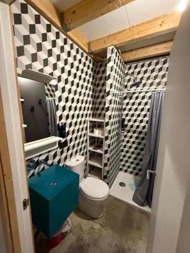 a bathroom with a toilet and a checkerboard wall at La Auténtica in Valencia