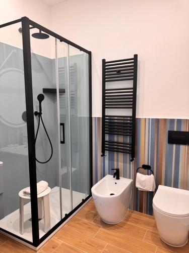 a bathroom with a shower and a toilet and a sink at B&B Vitruvio Suites in Formia