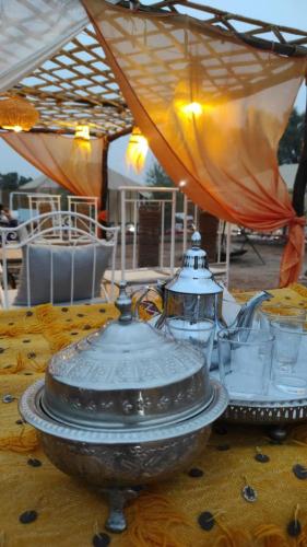 a table with a tea pot on top of it at Merzouga Desert Experience Camp-Erg Chebbi Sunset & Camel Ride in Merzouga