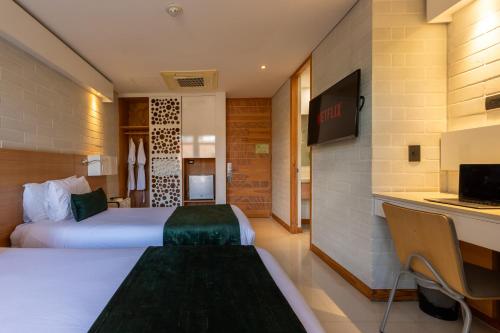a hotel room with a bed and a desk at Terra Biohotel in Medellín