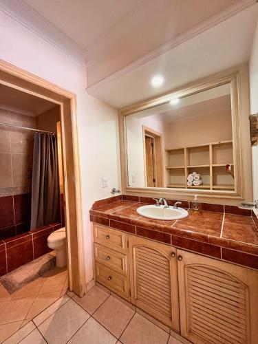 Un baño con lavabo, inodoro y espejo. en Bonito, Amplio, Acogedor, Cerca de Playa y con Alberca, en Cancún