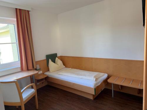 a small room with a bed and a chair at Hotel Zur Alten Schule in Pitten