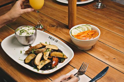 a table with a plate of food and a bowl of vegetables at Terra Biohotel in Medellín