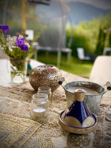 a table with a pot of coffee and a vase of flowers at Sonnes Apartment in Andelsbuch