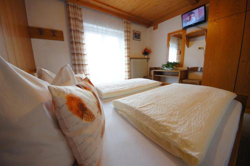 a bedroom with two beds and a window at Gasthof La Pli Apartments in San Vigilio Di Marebbe