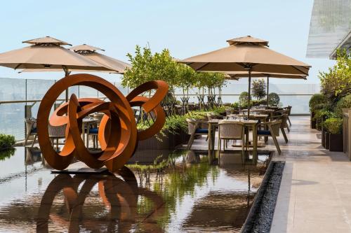 a restaurant with tables and umbrellas on a balcony at The St. Regis Shenzhen Bao'an in Shenzhen