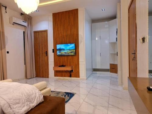 a bedroom with a bed and a television on a wall at KeeT luxurioushomes in Ikota