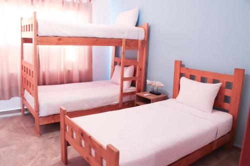 a room with two bunk beds and a bed at ÓRGANOS BEACH bungalows & suites in Los Órganos