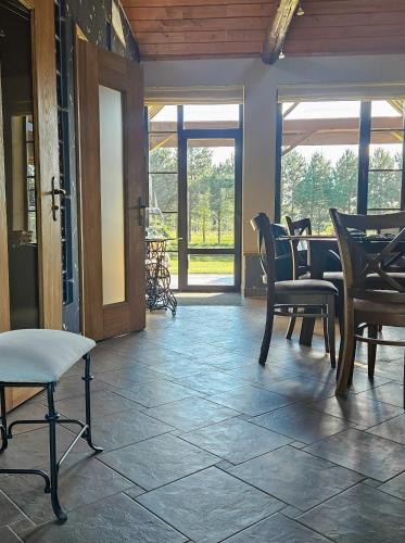 a living room with chairs and a table and a porch at Jauki Lauki in Lejasciems