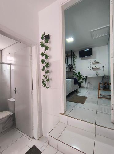 a living room with white walls and white tile floors at Aconchegante Casa no centro da cidade in Itatiba