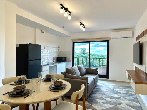 a kitchen and a living room with a table and a couch at Apartamento en Luque cerca de Asunción 310 in Luque