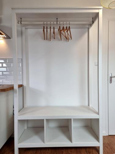 a closet with white shelves and wooden hangers at N5 - Une pépite au coeur de Valenciennes in Valenciennes