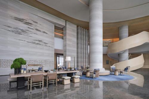 a lobby of a hotel with tables and chairs at Beihai Marriott Resort in Beihai