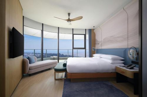 a bedroom with a large white bed and a couch at Beihai Marriott Resort in Beihai