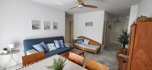 a living room with a blue couch and a chair at Apartamento Sabimar Playa in San Luis de Sabinillas