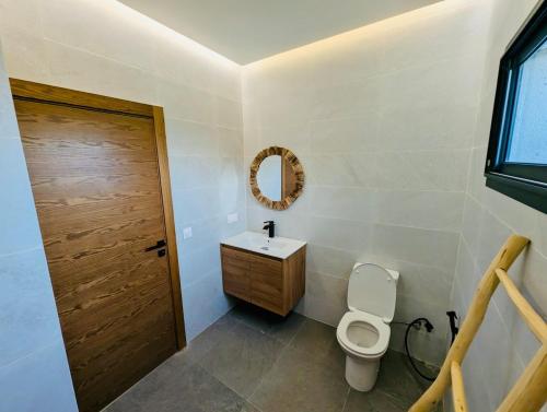 a bathroom with a toilet and a sink and a mirror at Villa 6chambres Aéroport de Fès Piscine Jacuzzi in Fès