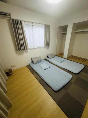 two large beds in a room with a window at Near the station, no fee parking, 1 limited group, quiet residence, 2 floors 3LDK, 18 minutes from Nippori, Akihabara, Ueno, Tokyo 30 minutes in Tokyo