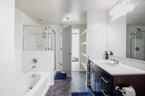 a white bathroom with a tub and a sink at Pentagon Luxe Apartments Arlington - Near DC in Arlington