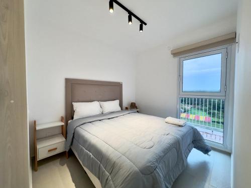 a bedroom with a bed and a large window at Apartamento en Luque cerca de Asunción 613 in Luque