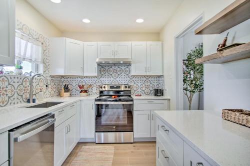 a kitchen with white cabinets and a stove at Centrally Located Tucson Home about 5 Mi to Dtwn! in Tucson