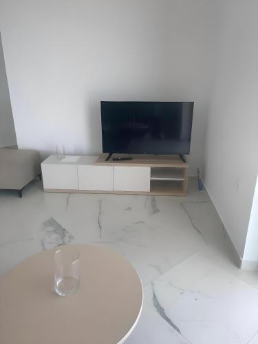 a living room with a flat screen tv on a cabinet at Endless blue Apartments in Dhërmi