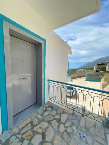 a door on the side of a building with a balcony at Endless blue Apartments in Dhërmi