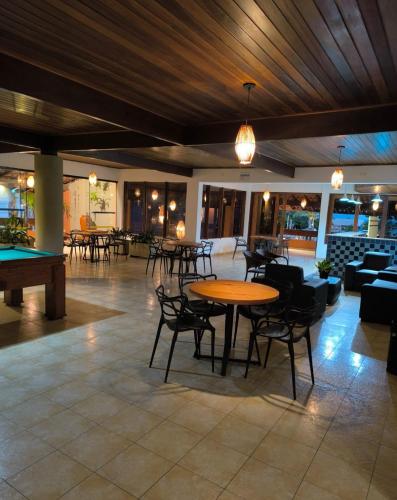 a lobby with tables and chairs and a pool table at Praia Boulevard Flat Porto Bahia in Porto Seguro
