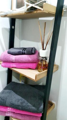 a shelf with pink and purple towels on it at Luxe-Design Imperio II- Petit Déjeuner 5min de la Mer in Praia